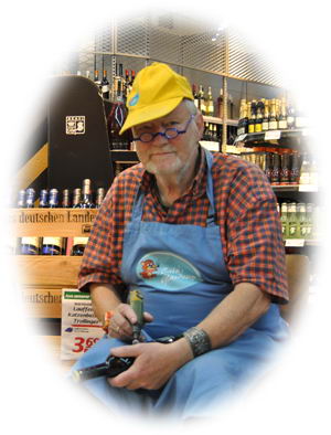 Peter Eicke mit gelber Mütze und Schürze, das Gravurwerkzeug in der Hand